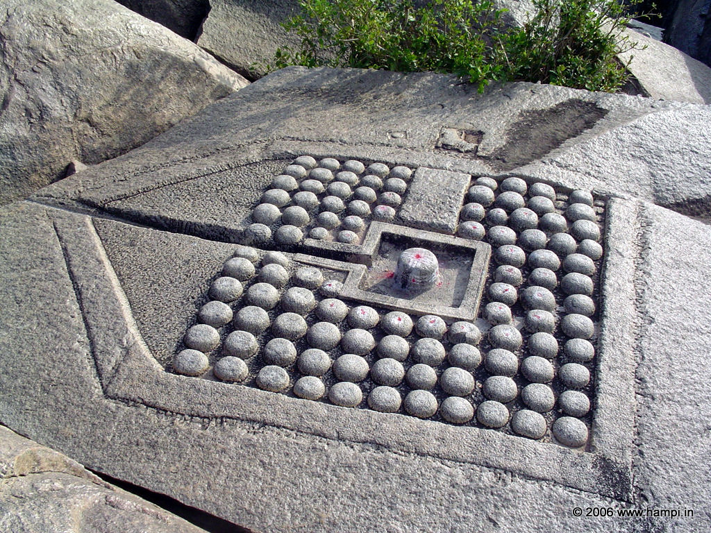 108 Shiva lingas carved on a large sheet of rock by the riverside.
