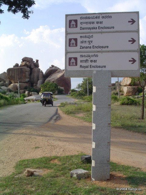  The large boulder in the background , almost projecting on to the road to Hampi is popularly called Akka Tangi Gudda, the sister boulders. The picture was taken from the deviation to the Underground Siva Temple from the  Hampi main road. 