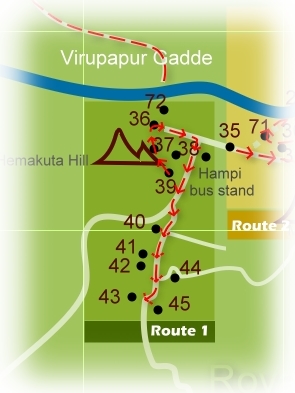 Route 1: Covers the Sacred Center surrounding the Virupaksha Temple vicinity. Start from the Sasivekalu Ganesha pavilion on the slops of the Hemakuta Hill facing the main road. This is on the south end of the hill.

Climb up further (it’s a gentle slope) to explore the Hemakuta Hill Shrines in a south to north direction. (there are many temples and gateways to see here). Exit the Hemakuta Hill through a massive, incomplete tower on the northern slops. You’ll reach the main entrance tower of Virupaksha Temple.

After Virupaksha Temple visit take the Hampi Bazaar and come towards the Hampi Bus stand area. Head further south on the main road. The Kadalekalu Ganesha and Sasivekalu Ganesha shrines appears on your left, by the slops of the Hemakuta Hill.

Now you are back to the point where begin this walk. You may pick up your bicycle/moped parked before venturing on to Hemakuta Hill, and head for the Krishna Temple and the Krishna Bazaar located southward. After this head further south till you spot the signboard for the Lakshmi Narasimha Temple and the adjacent Badavilinga shrine. Take a detour by walk (bikes/mopeds not allowed). Back to the main road. Head further south. The road makes a bend around the Chandikesvara Temple and the living Uddana Veerabhadra Temple. You’ll also spot a tall monolithic lamp-post by the corer of the Chandikeshava Temple and a sati stone (memorial of wife who burned herself in the pyre of her dead husband) beneath it. So this is the culmination of your sacred center lap.

You can now head for the cluster 3, that is the Royal Center cluster. This itinerary starts at Sisters Stones, which is about 500 meters/0.3 mile south.

You may even do the Route 1 in reverse direction, that is start from Chandikeshava Temple and end at the Hampi Bazaar/Virupaksha Temple locality.In this case you can proceed for the Route 2 or Route 5