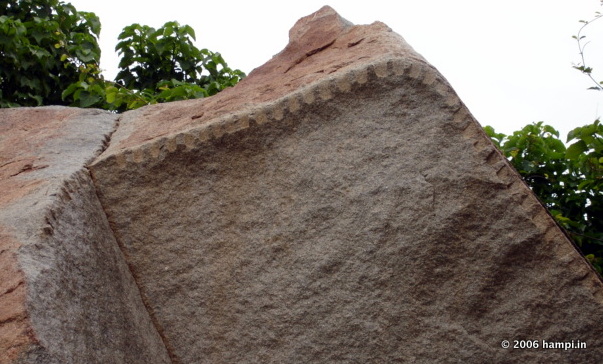 Note the serration along the edges of the boulder. This ancient technique  is used to slice the boulder for building the structures in Hampi.